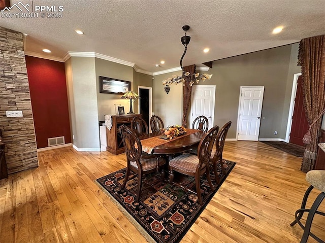 dining area featuring visible vents, baseboards, ornamental molding, a notable chandelier, and wood-type flooring