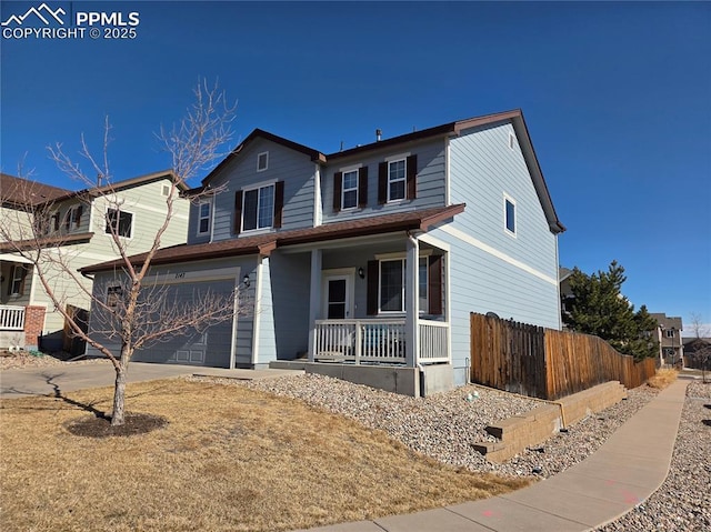 traditional home with a porch, fence, a garage, and driveway