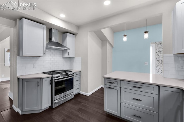 kitchen with gas range, wall chimney exhaust hood, dark wood-style flooring, and light countertops