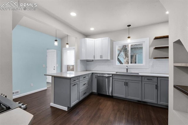 kitchen featuring a healthy amount of sunlight, a peninsula, a sink, gray cabinetry, and dishwasher