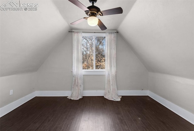 additional living space with baseboards, hardwood / wood-style floors, a ceiling fan, and vaulted ceiling