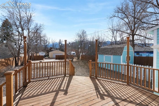 wooden deck featuring a fenced backyard and an outdoor structure