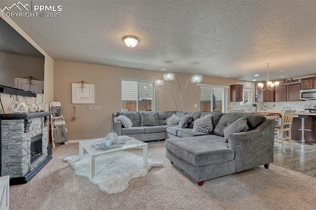 living area with a wealth of natural light, light carpet, an inviting chandelier, and a fireplace