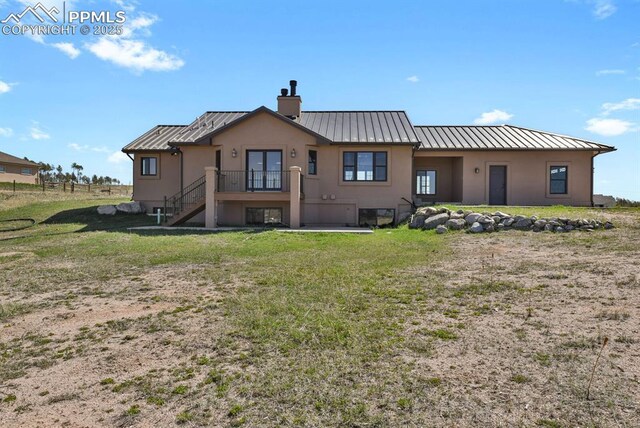 14060 Black Forest Rd, Colorado Springs, CO 80908 - rear view of house with a chimney, a standing seam roof, stucco siding, and metal roof