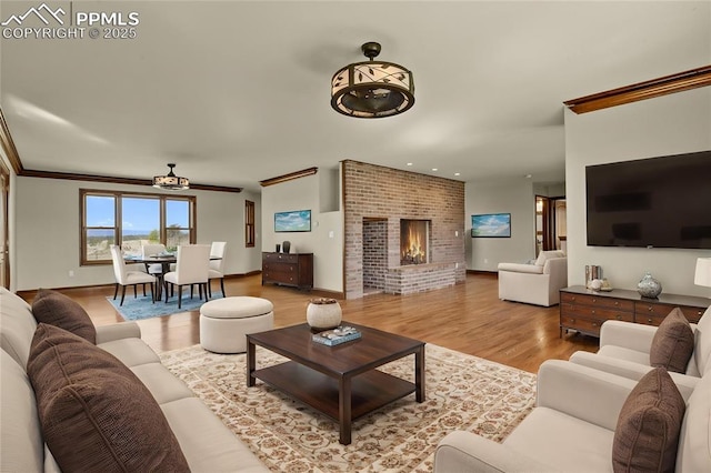 14060 Black Forest Rd, Colorado Springs, CO 80908 - living area featuring baseboards, recessed lighting, a brick fireplace, wood finished floors, and crown molding