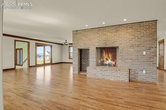 14060 Black Forest Rd, Colorado Springs, CO 80908 - unfurnished living room with recessed lighting, wood finished floors, crown molding, baseboards, and a brick fireplace