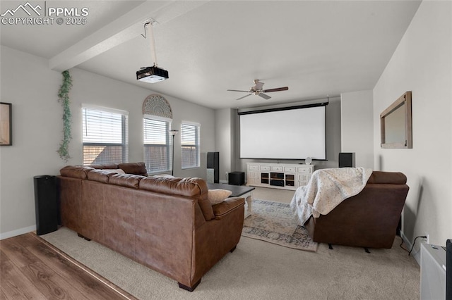 cinema featuring baseboards, beam ceiling, wood finished floors, and a ceiling fan