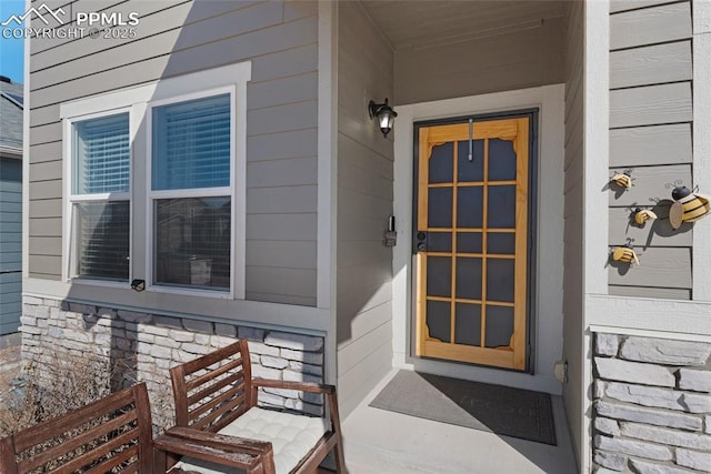 doorway to property featuring stone siding