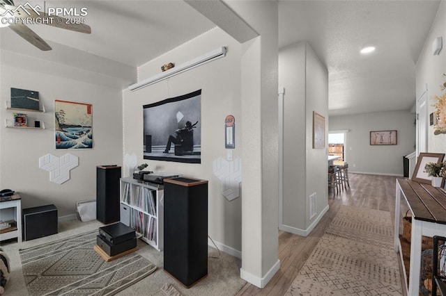 hall featuring visible vents, baseboards, and wood finished floors