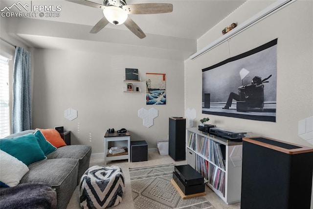 living area with baseboards, light colored carpet, and ceiling fan