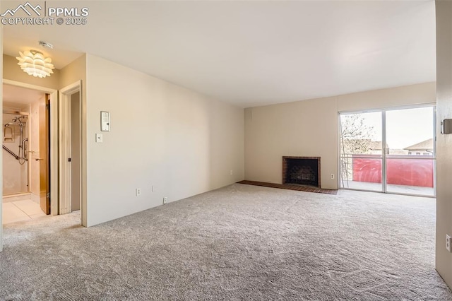 unfurnished living room featuring a brick fireplace and carpet floors