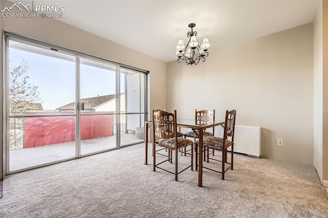 dining space with a notable chandelier and carpet flooring