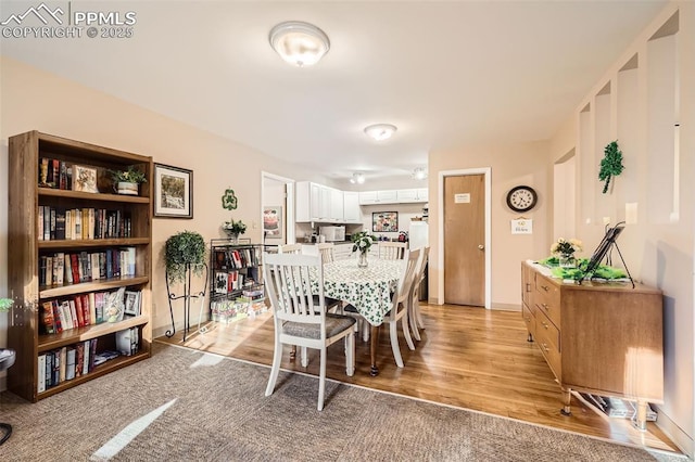 dining area featuring light wood finished floors and baseboards