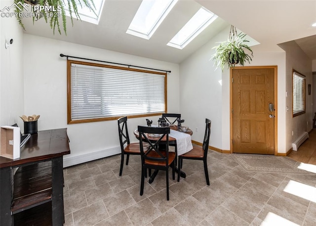 dining space with a baseboard heating unit, lofted ceiling with skylight, and baseboards