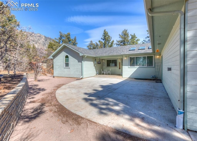 rear view of property with a patio, fence, and a mountain view