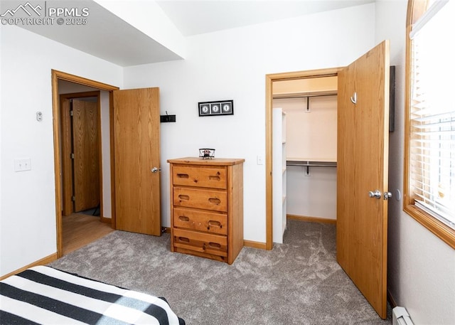 bedroom featuring a closet, carpet flooring, baseboards, and a baseboard radiator