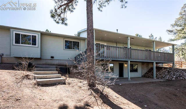 back of house with a deck and a patio area