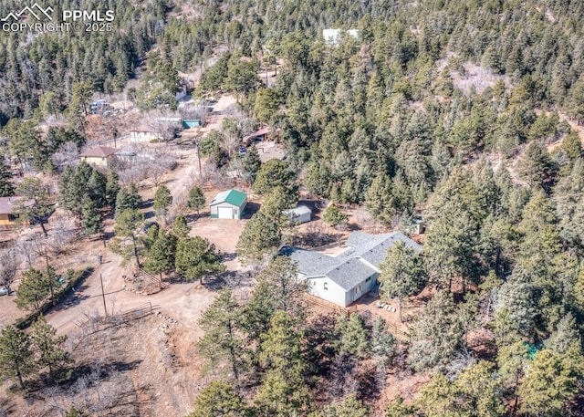 birds eye view of property featuring a forest view