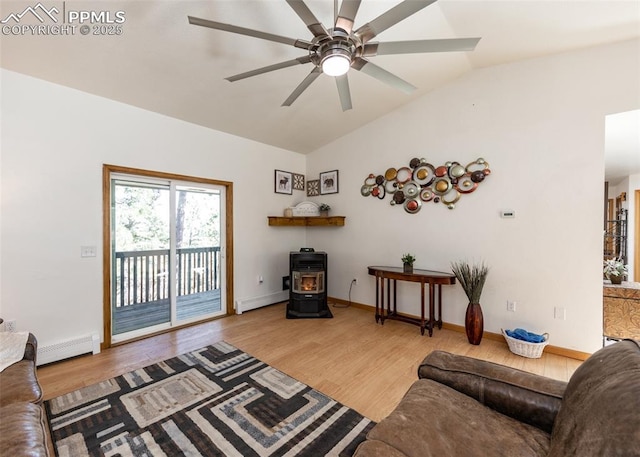 living area featuring light wood finished floors, a wood stove, ceiling fan, vaulted ceiling, and baseboard heating