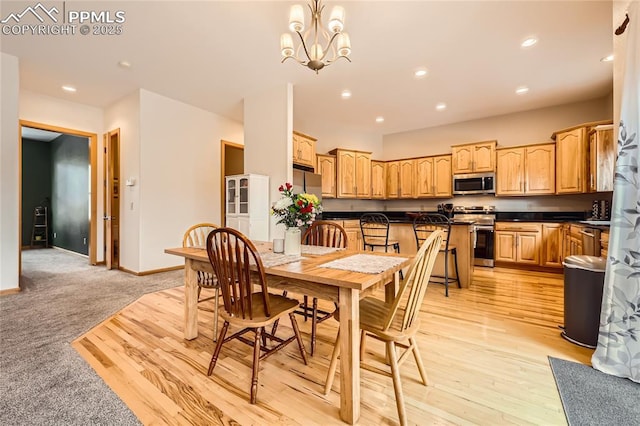 dining space featuring recessed lighting, baseboards, a notable chandelier, and light wood finished floors