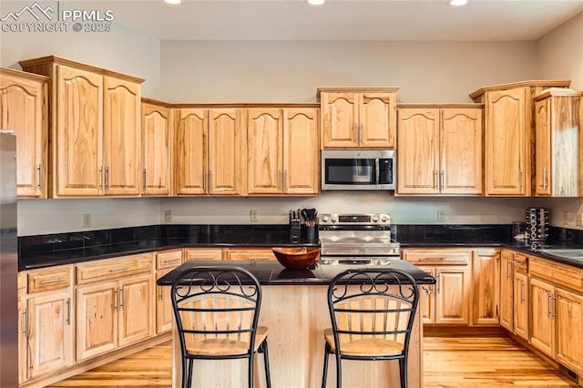 kitchen featuring a center island, recessed lighting, appliances with stainless steel finishes, and light brown cabinetry