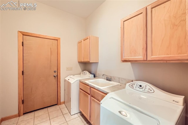 washroom with light tile patterned flooring, cabinet space, washer and dryer, and a sink