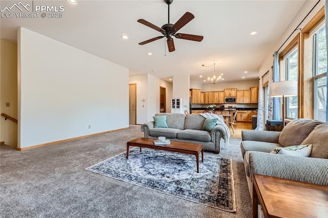 living room featuring light carpet, recessed lighting, ceiling fan with notable chandelier, and baseboards