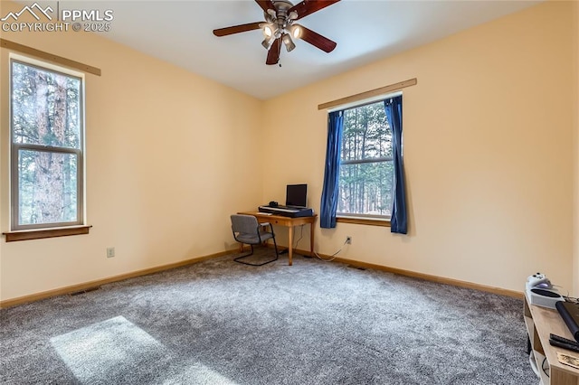 unfurnished office with baseboards, a ceiling fan, and carpet flooring