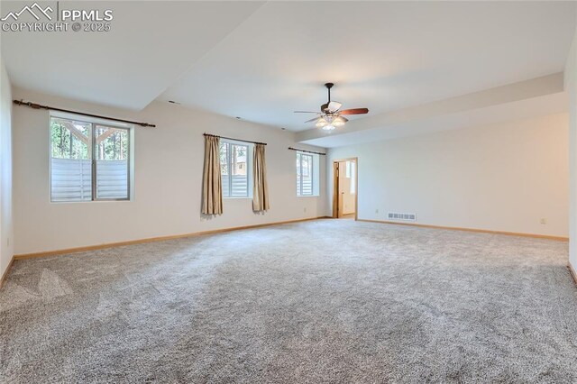 empty room featuring visible vents, carpet flooring, baseboards, and ceiling fan