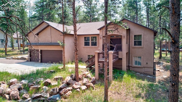 view of front of property with a garage, driveway, and stucco siding