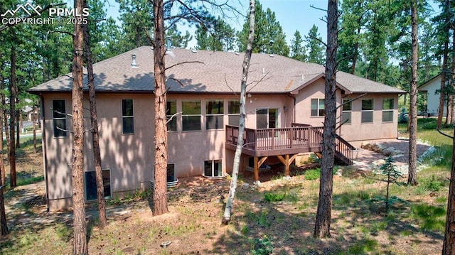 back of house featuring stucco siding, stairs, a deck, and roof with shingles