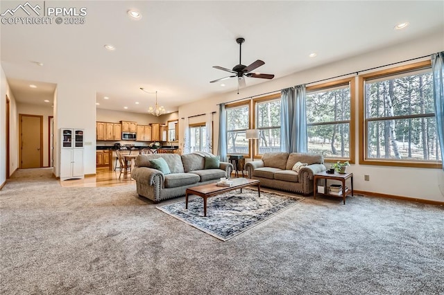 living room with ceiling fan with notable chandelier, recessed lighting, baseboards, and light carpet