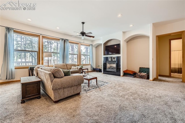 carpeted living area with recessed lighting, baseboards, a glass covered fireplace, and a ceiling fan