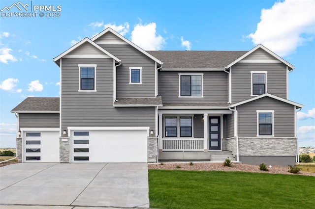 view of front facade featuring a front yard, driveway, a porch, a garage, and stone siding