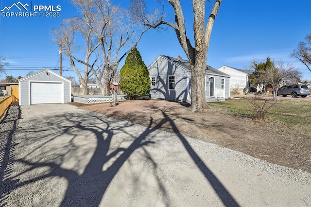 view of side of home with an outbuilding, fence, a garage, and driveway