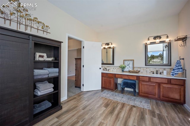 14650 Eastonville Rd, Elbert, CO 80106 - full bath featuring double vanity, wood finished floors, baseboards, tasteful backsplash, and a sink
