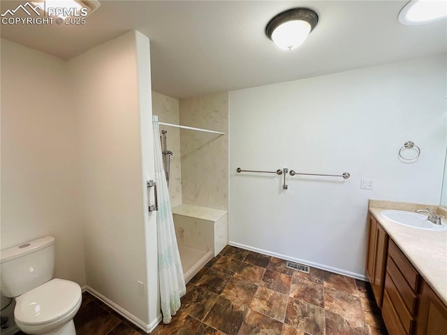 full bathroom with curtained shower, toilet, stone finish flooring, and baseboards