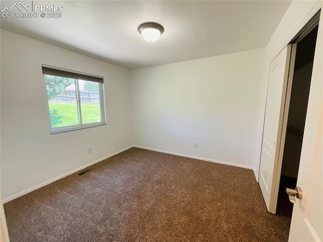 interior space with visible vents, baseboards, and dark carpet