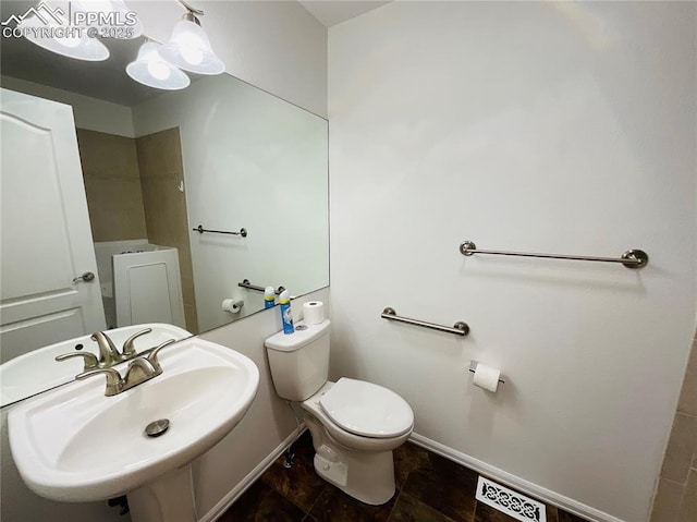 half bathroom featuring toilet, baseboards, visible vents, and a sink