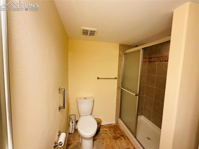 full bathroom featuring a shower stall, toilet, and visible vents