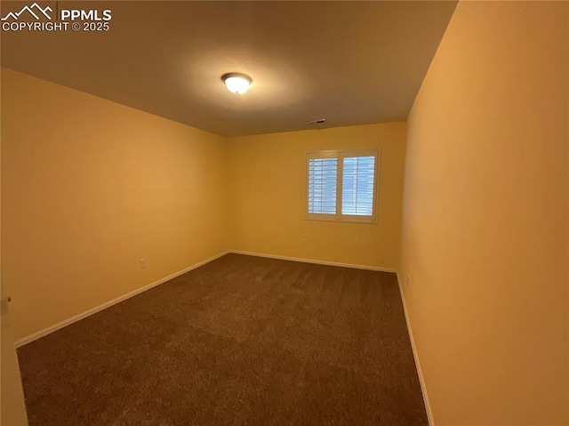 empty room with visible vents, baseboards, and dark colored carpet