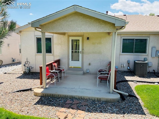 back of house with a patio, central AC unit, and stucco siding