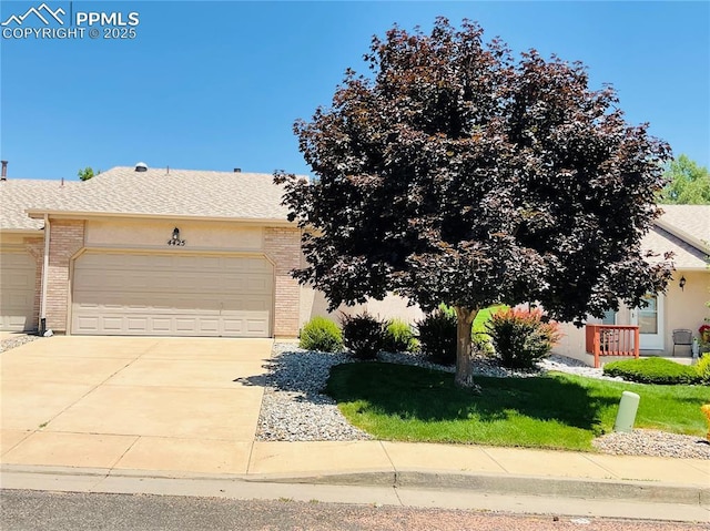 obstructed view of property featuring brick siding, driveway, a front lawn, and a garage