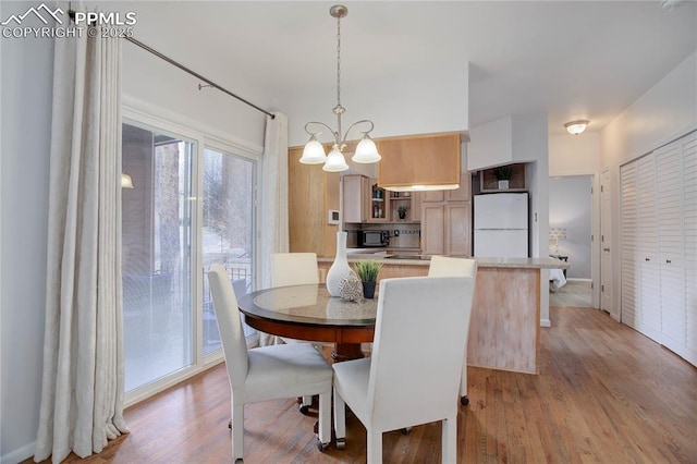 dining space with light wood-style flooring and a chandelier