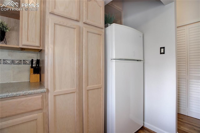 kitchen featuring light countertops, open shelves, freestanding refrigerator, tasteful backsplash, and light brown cabinetry