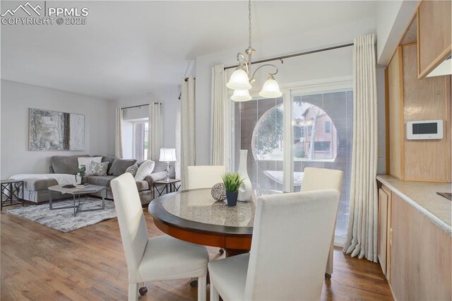 dining room with dark wood-type flooring and a chandelier