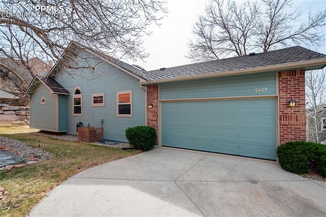 view of front facade featuring driveway, brick siding, and a garage