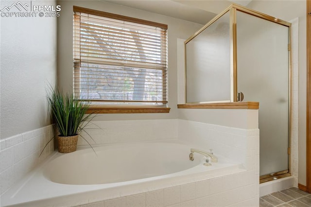 full bathroom featuring a garden tub and a shower stall