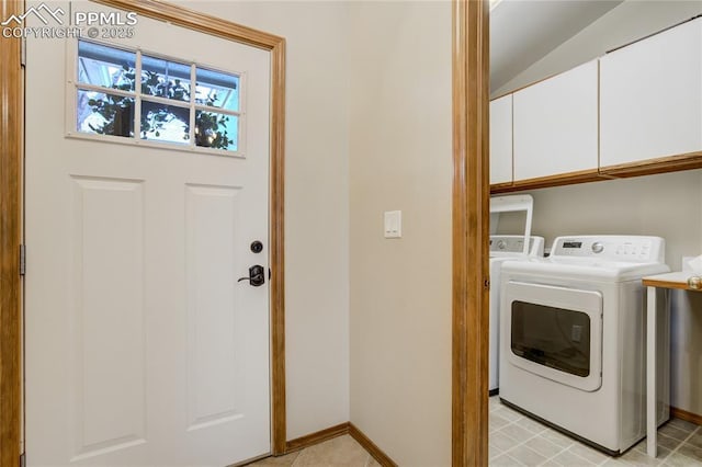 laundry room featuring baseboards, washing machine and dryer, and cabinet space
