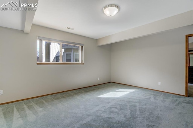 spare room featuring baseboards, visible vents, carpet, and beam ceiling